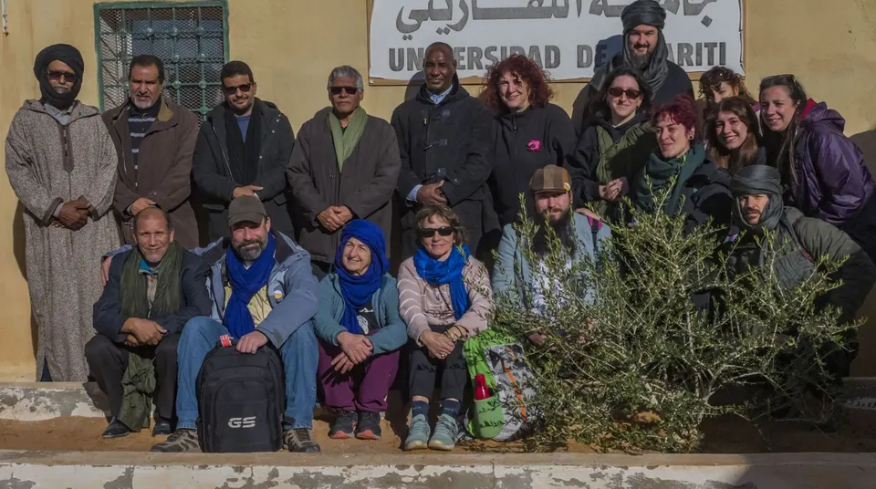 Foto de grupo de la expedición con anfitriones saharauis ante un edificio