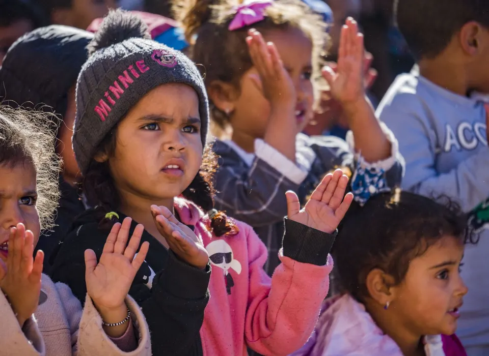 Niñas y niños pequeños aplauden durante el show